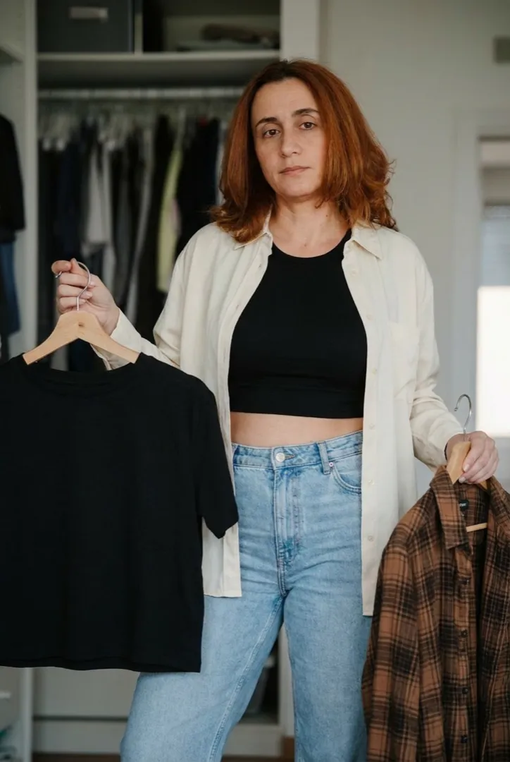 Woman holding garments, deciding what to wear